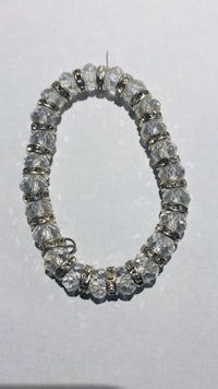 a bracelet with clear crystal beads on a white surface