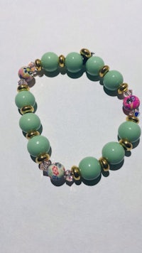 a bracelet with green beads and pink beads